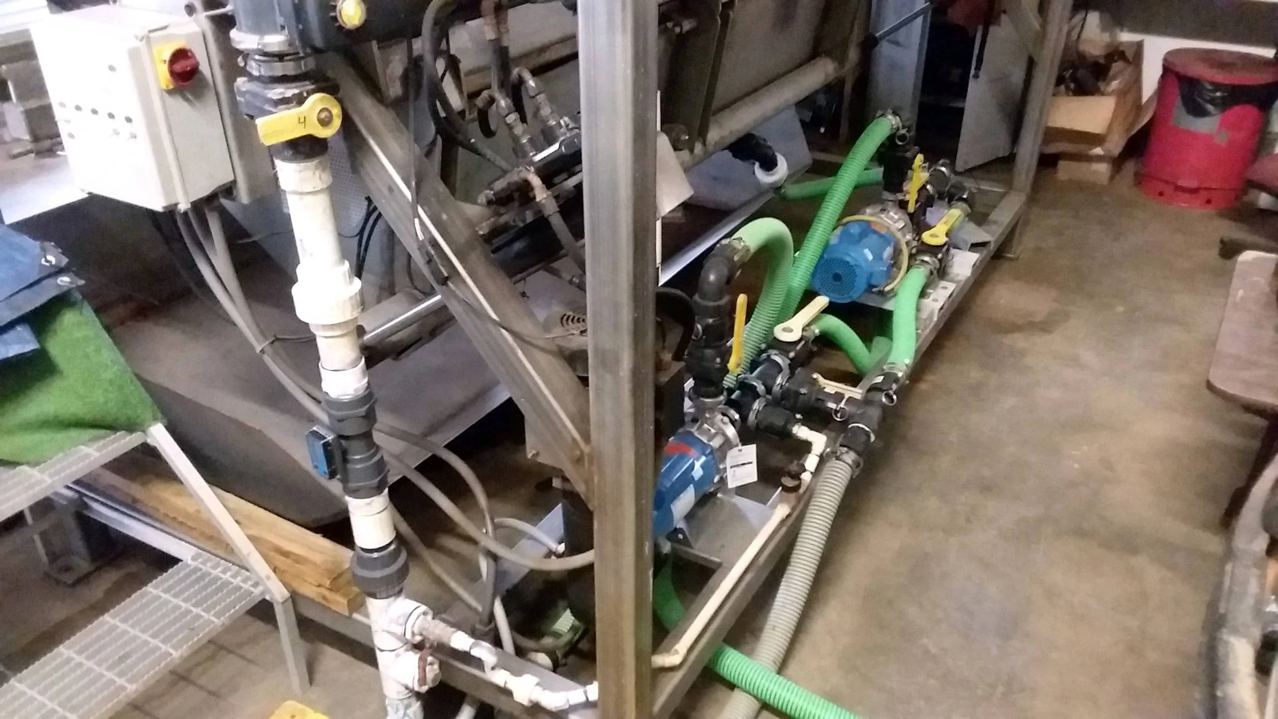 A mock brine shop assembly area shows pump hoses, valves, and piping used in diagnosing pump malfunctions.